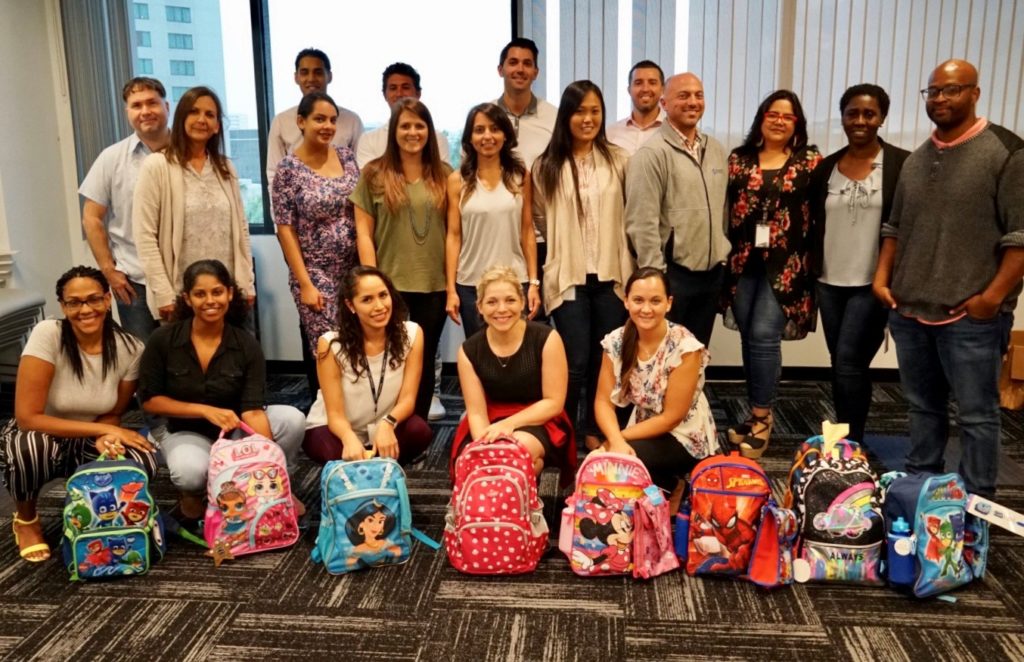 Hayes Locums employees with backpacks for 4KIDS back to school drive